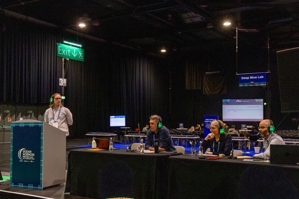 Panel members sit behind a desk and present the FMRI Town Hall to the community